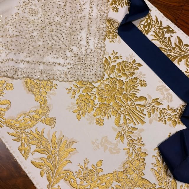 Brocado dorado con blonda y cinta azul